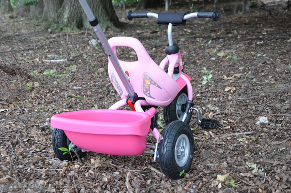 De roze Puky heeft een kiepbak en duwstang.